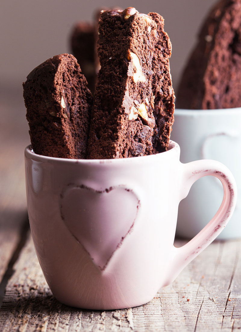 Chocolate hazelnut espresso biscotti inside a white cup with a heart