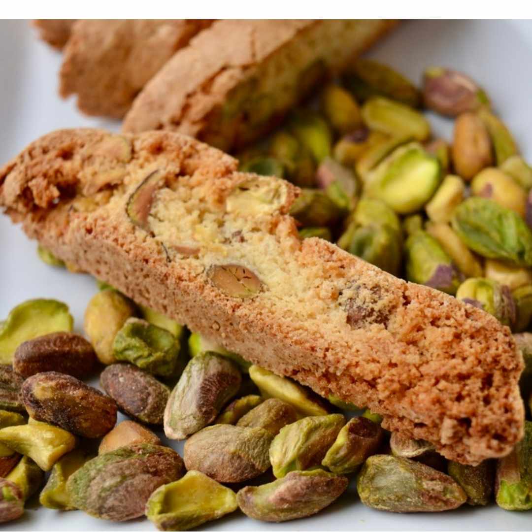Pistachio biscotti stacked with orange zest and whole pistachios
