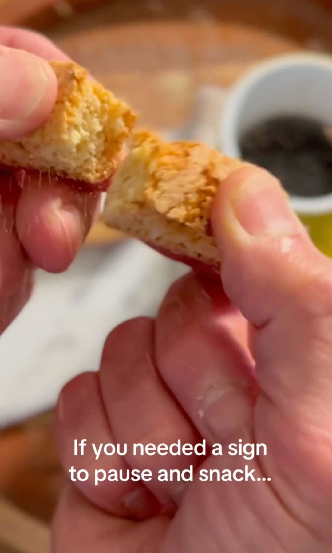 Hands breaking a Lemon Biscottini with text If you needed a sign to pause and snack