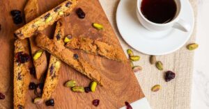 Cranberry pistachio biscotti with Americano coffee highlighting bright fruit and nut flavors