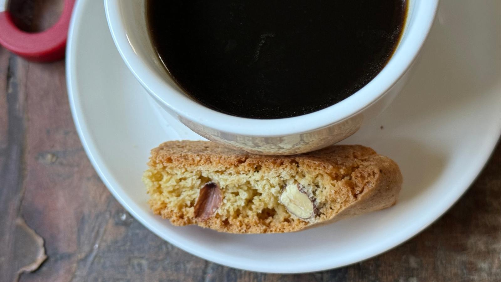 Almond Biscotti on a saucer next to a cup of coffee in soft morning light