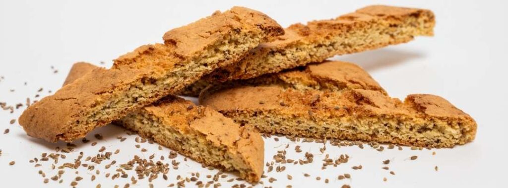 anise biscotti arranged on a platter with anise seeds scattered around for a rustic Italian look.