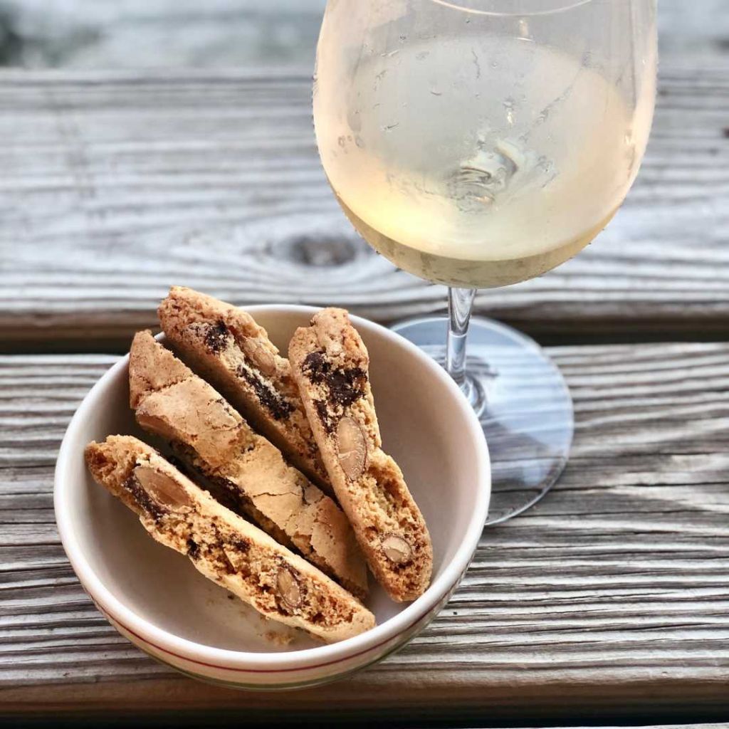 Plate of assorted Italian biscotti on a table beside wine glasses