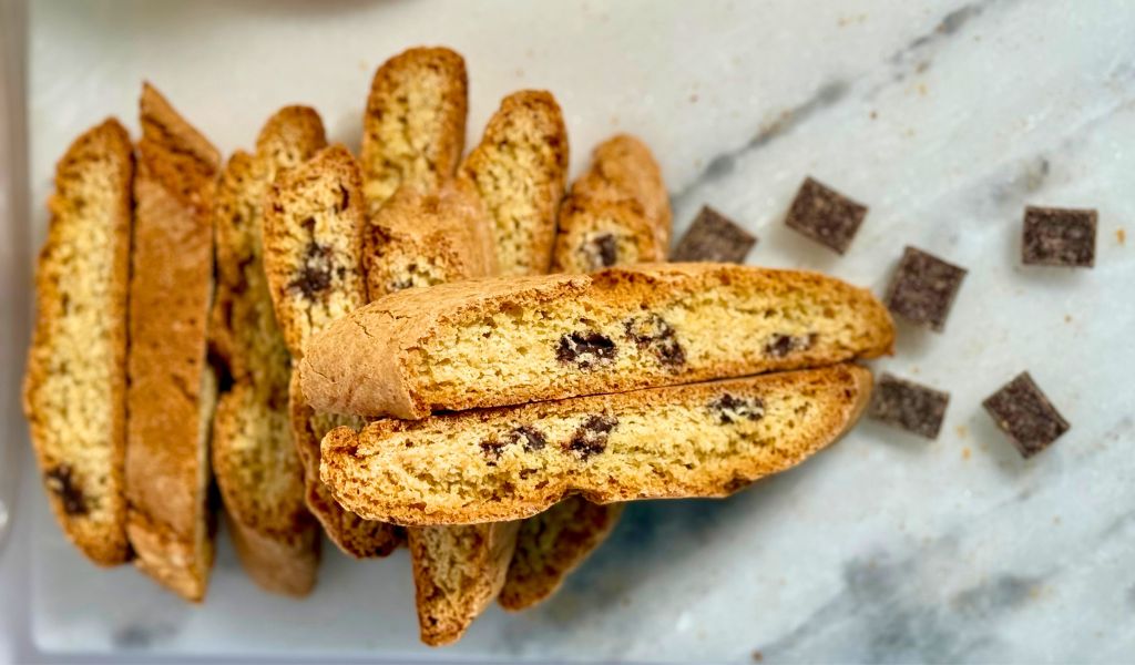 Chocolate Chunk Biscottini stacked neatly on a serving dish, showing real Belgian chocolate chunks in each bite-size cookie.