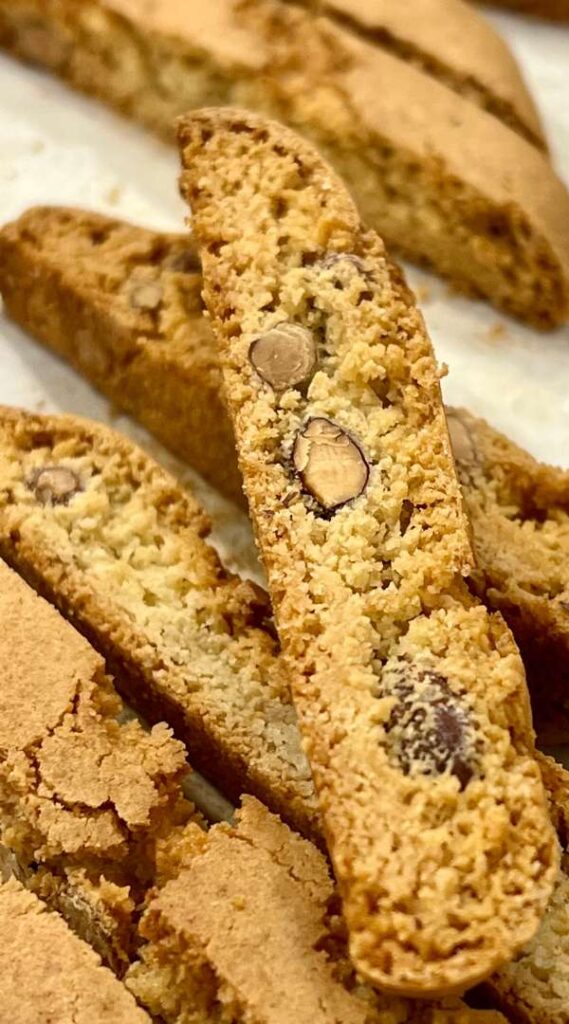 Almond biscotti sliced on a board beside an espresso cup
