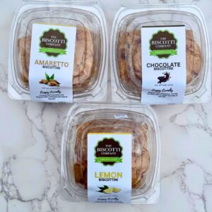 Packaged Italian biscottini trio showing amaretto, chocolate, and lemon flavors from The Biscotti Company