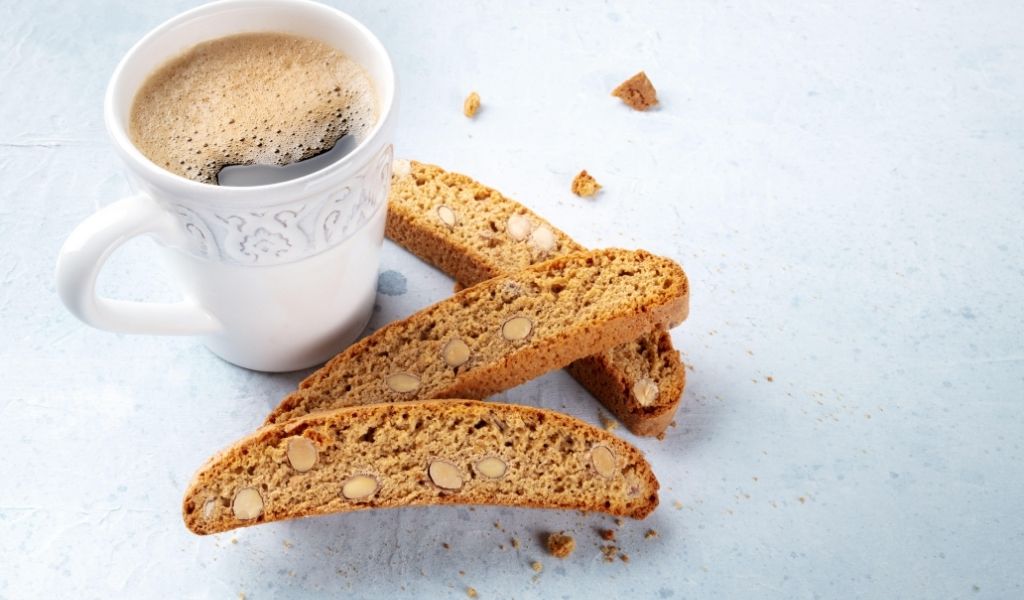 Pumpkin Spice Biscotti next to a warm cup of coffee