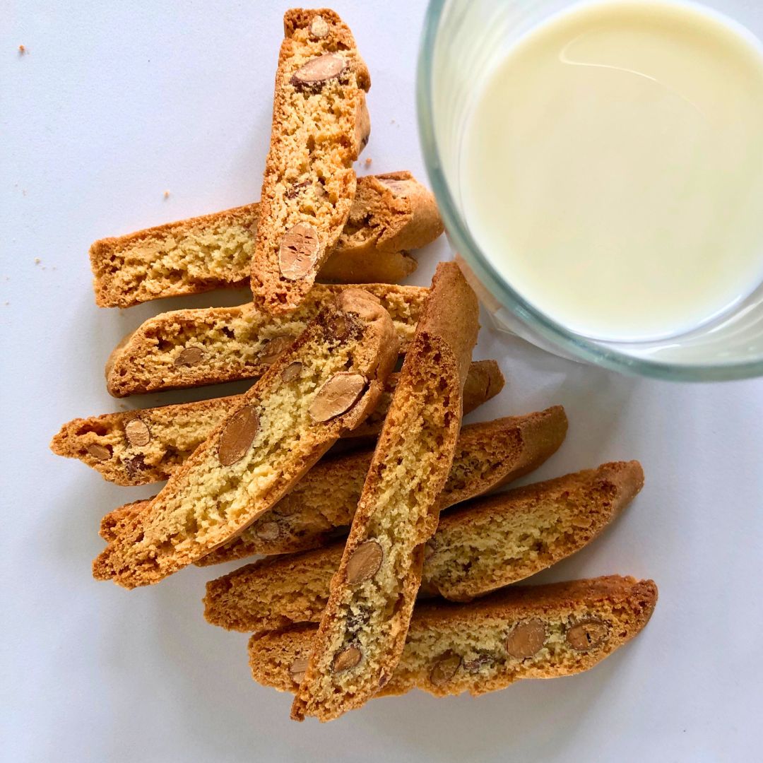 Stacked Almond Biscotti with Glass of Milk Stack of almond biscotti with a glass of milk in the background