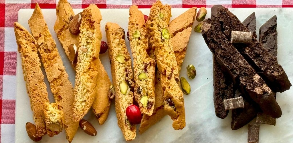 The Hampton Trio biscotti gift set arranged on a marble plate with almond, cranberry pistachio, and double chocolate flavors
