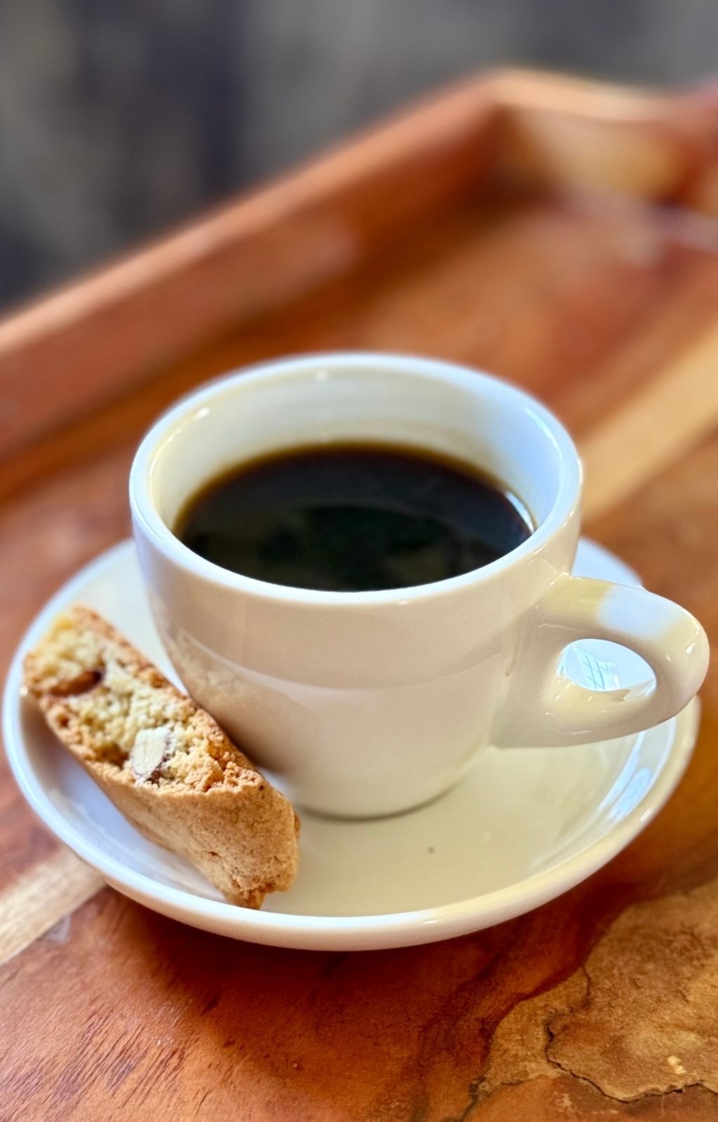 Chocolate almond biscotti next to a cup of coffee ready for dunking