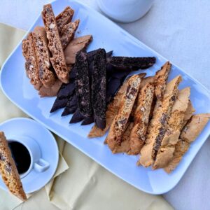 Plate of assorted chocolate biscotti from The Biscotti Company Chocolate Lovers Four-Pack served with a cup of coffee