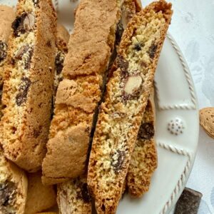 Dark chocolate orange almond biscotti on a plate with orange peel