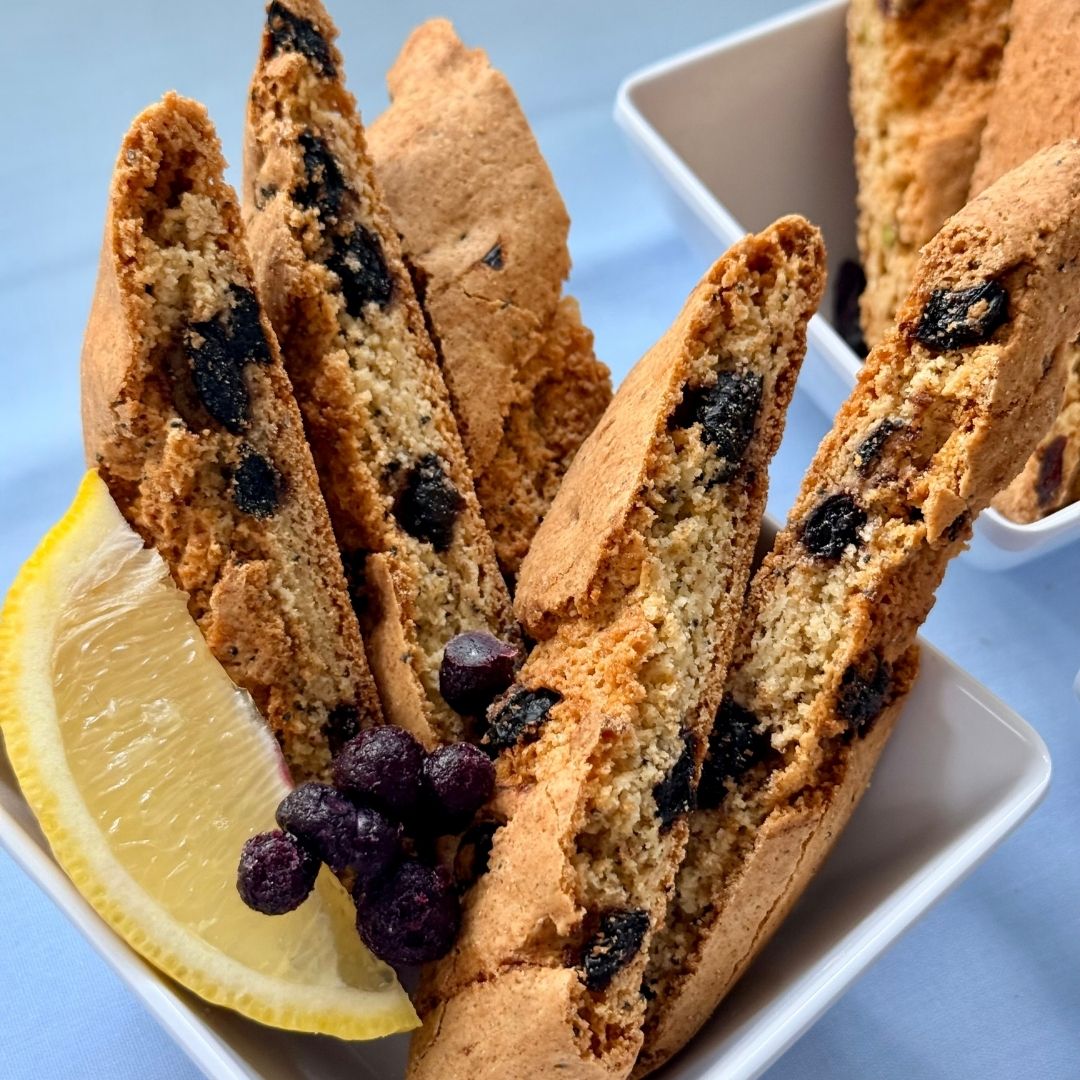 Blueberry lemon biscotti with poppy seeds close-up with lemon wedge and blueberries