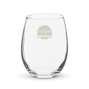 Close-up of a clear glass tilted on its side against a white background, with a blurred circular logo on the glass's side.
