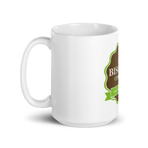White ceramic mug with a brown decorative badge and green border visible on the side.