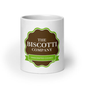 White mug with The Biscuit Company logo: brown badge outlined in green and a green ribbon reading Handcrafted Cookies.