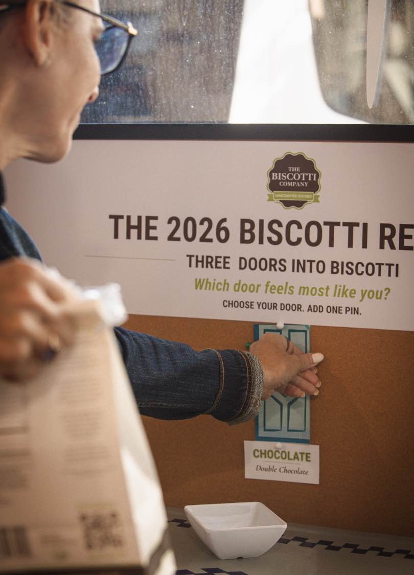 Customer places a pin on the Chocolate door after tasting Double Chocolate biscotti during the Three Doors experience